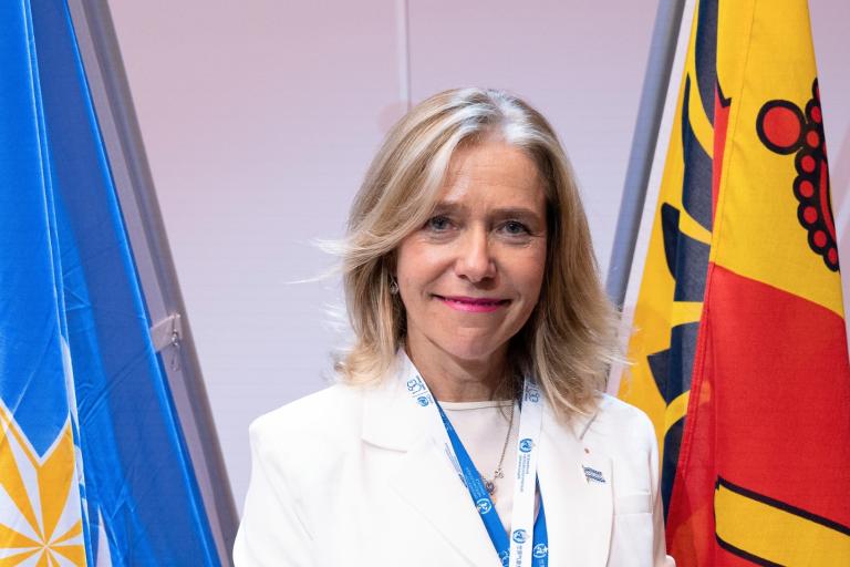 Celeste Saulo in front of the WMO  and Geneva Canton flags